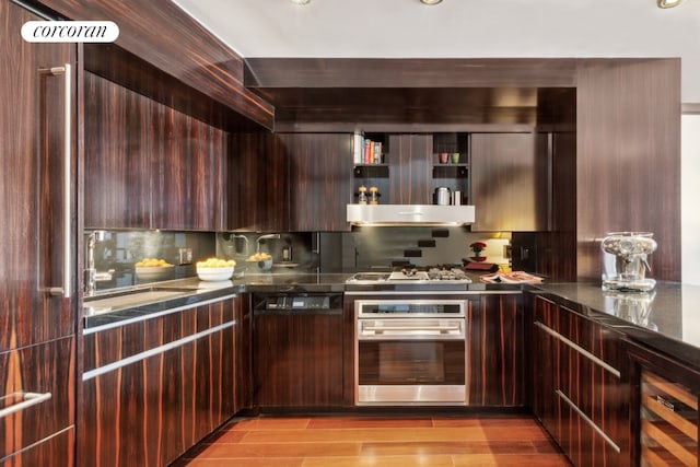 kitchen featuring dark brown cabinetry, sink, oven, gas stovetop, and light hardwood / wood-style flooring