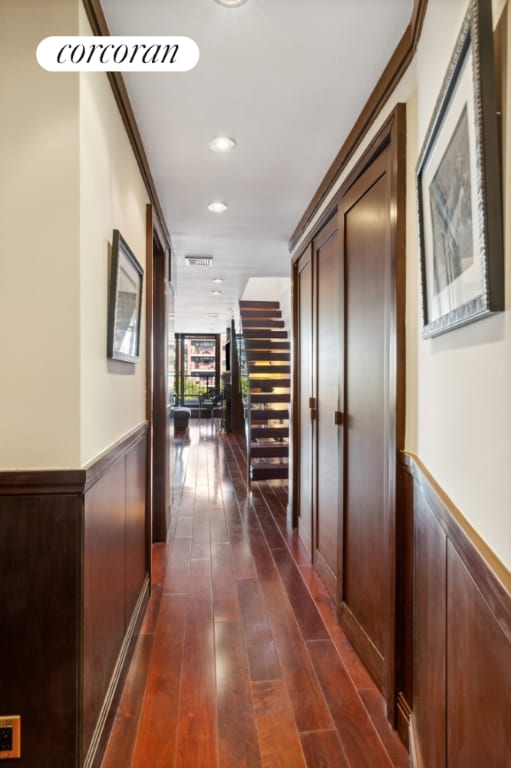 hall with dark wood-type flooring and crown molding