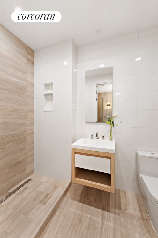 bathroom featuring tile walls, toilet, and vanity