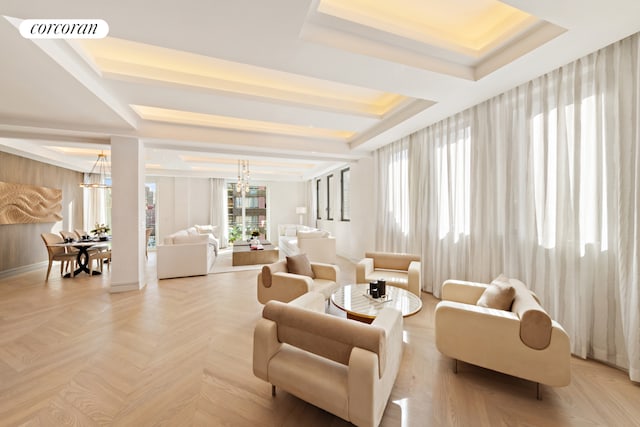 living room featuring an inviting chandelier, a raised ceiling, and light parquet flooring