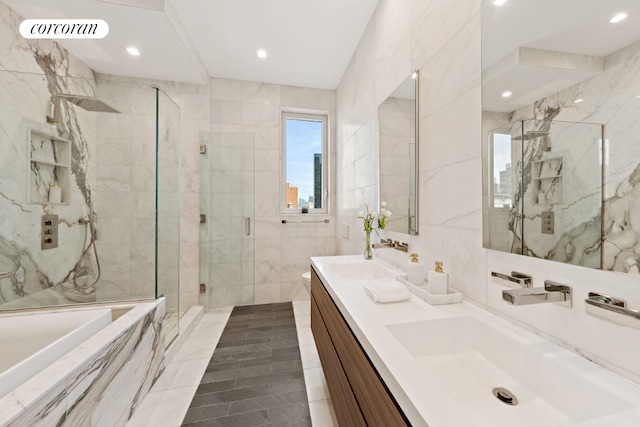 bathroom with independent shower and bath, tile walls, and vanity