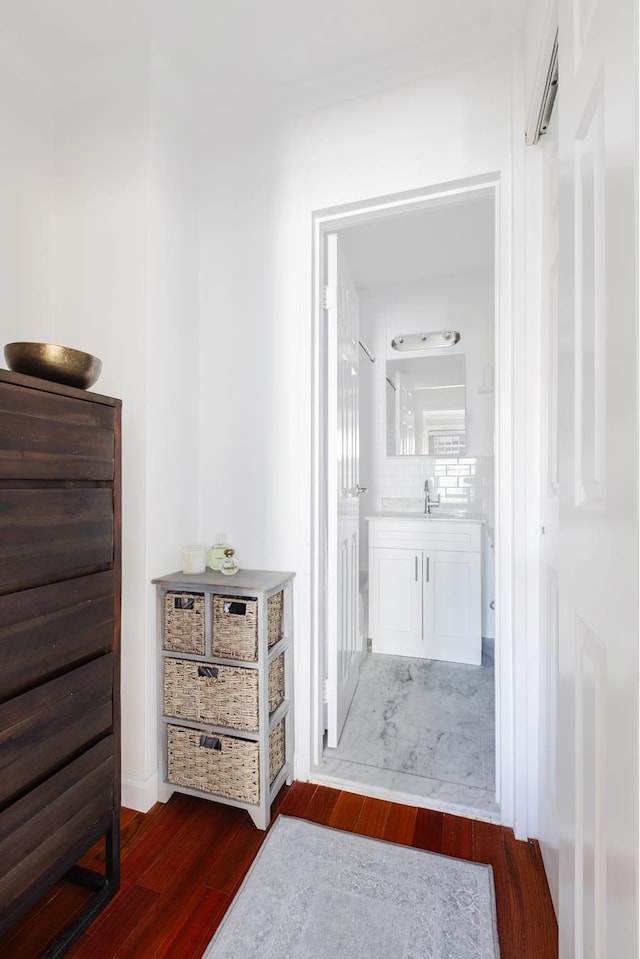 hallway with dark wood-style flooring and a sink