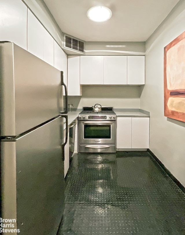 kitchen with visible vents, white cabinets, stainless steel appliances, and baseboards