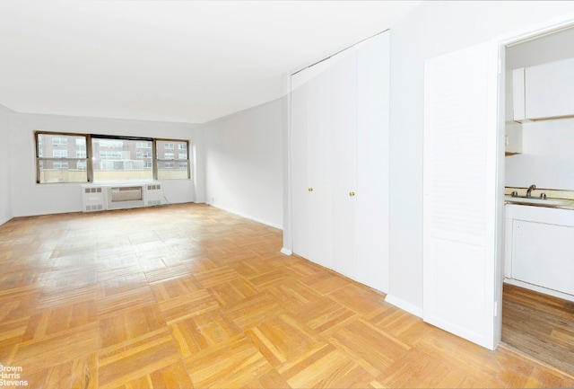 unfurnished living room featuring light parquet floors and sink