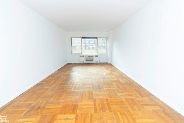 empty room with light parquet flooring and radiator