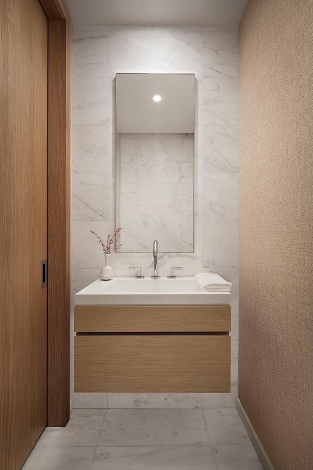 bathroom featuring vanity, tile walls, and marble finish floor