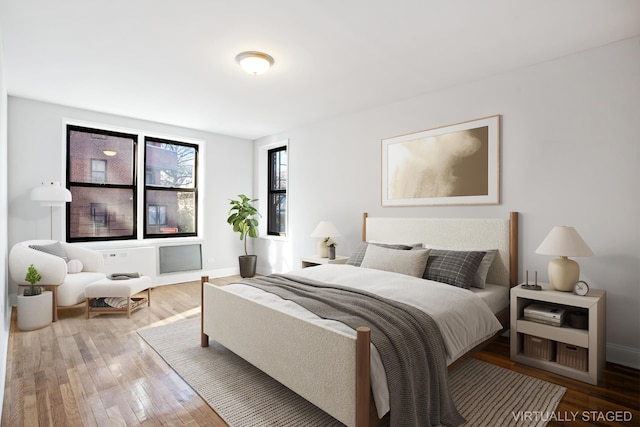 bedroom with baseboards and wood-type flooring