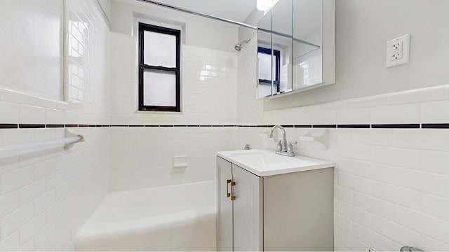 bathroom with vanity, tile walls, and bathing tub / shower combination