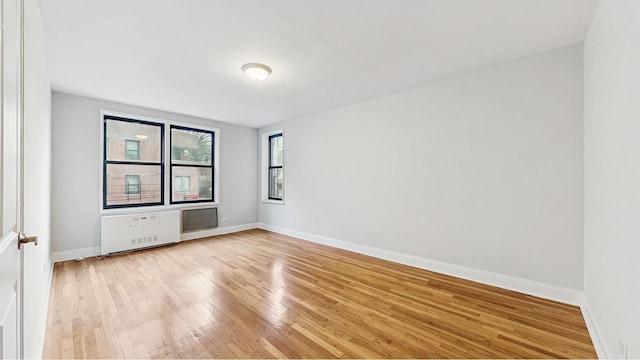 unfurnished room featuring baseboards and light wood-type flooring