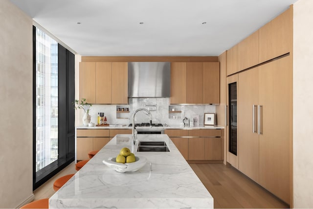 kitchen featuring decorative backsplash, light stone countertops, and modern cabinets