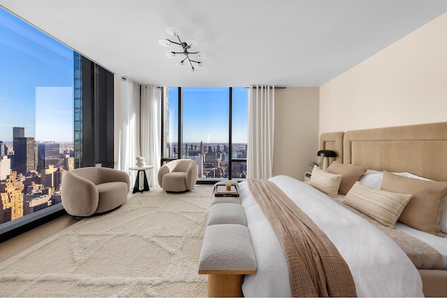 bedroom with expansive windows, a view of city, and an inviting chandelier