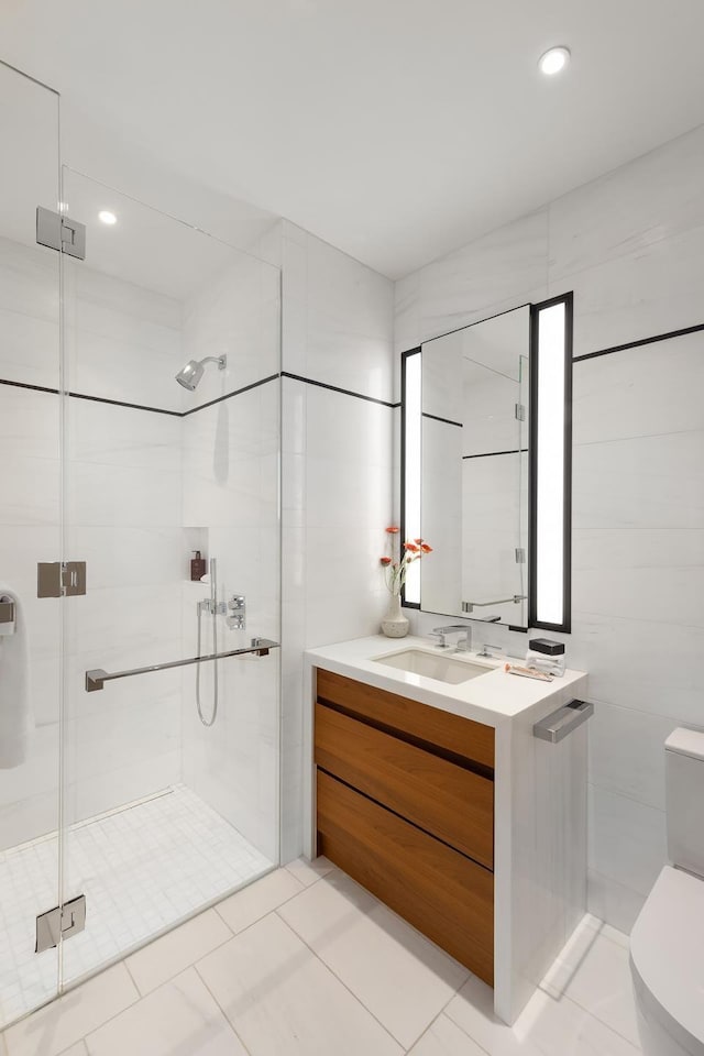 full bathroom featuring vanity, tile walls, toilet, and a stall shower