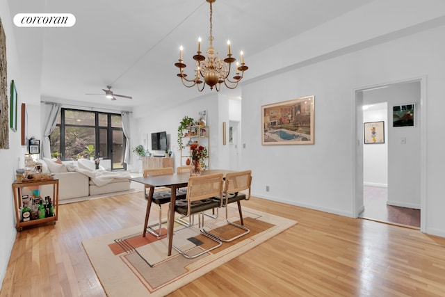 dining space featuring ceiling fan with notable chandelier, wood finished floors, visible vents, and baseboards