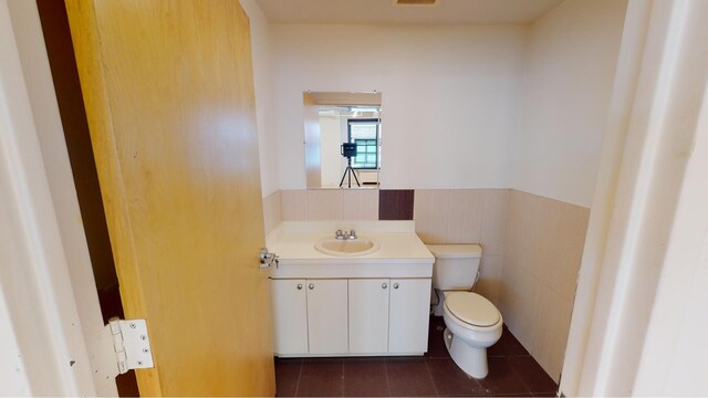 315 W 36th St Unit 12B, New York City, NY 10018 - bathroom with toilet, wainscoting, vanity, and tile patterned flooring