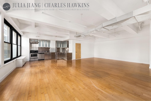 315 W 36th St Unit 12B, New York City, NY 10018 - unfurnished living room featuring light wood-type flooring, beam ceiling, and rail lighting