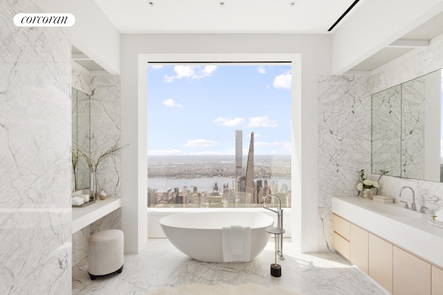 bathroom featuring a water view, vanity, and a bath