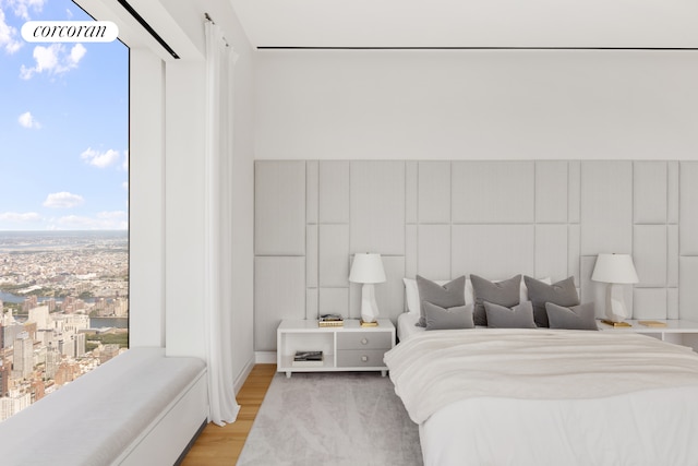 bedroom with multiple windows and light wood-type flooring