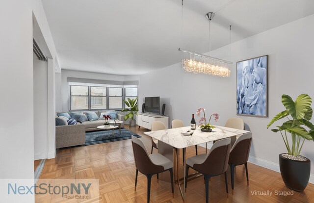 dining area featuring a chandelier and light parquet floors