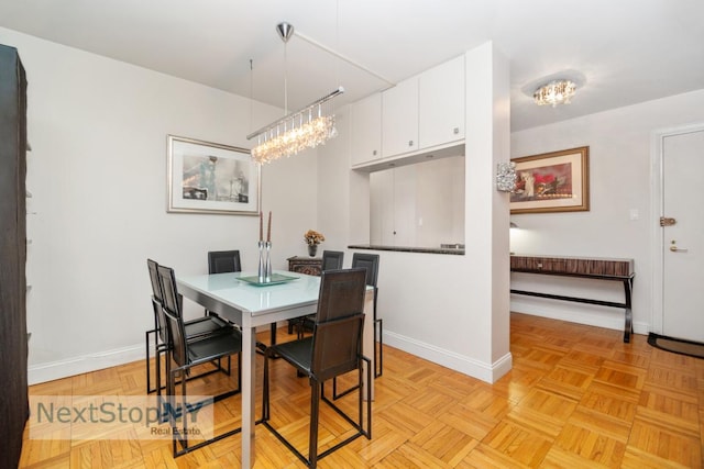 dining space with light parquet floors and a chandelier