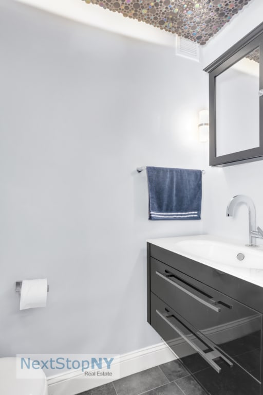 bathroom with tile patterned floors and vanity