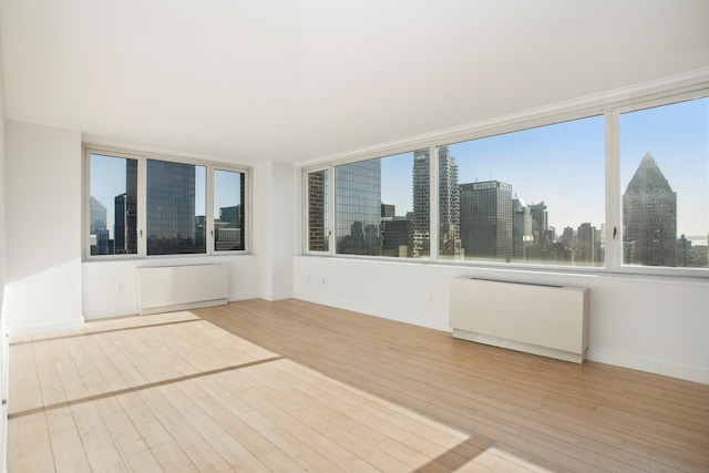 322 W 57th St Unit 55S1, New York City, NY 10019 - unfurnished sunroom featuring radiator and a city view