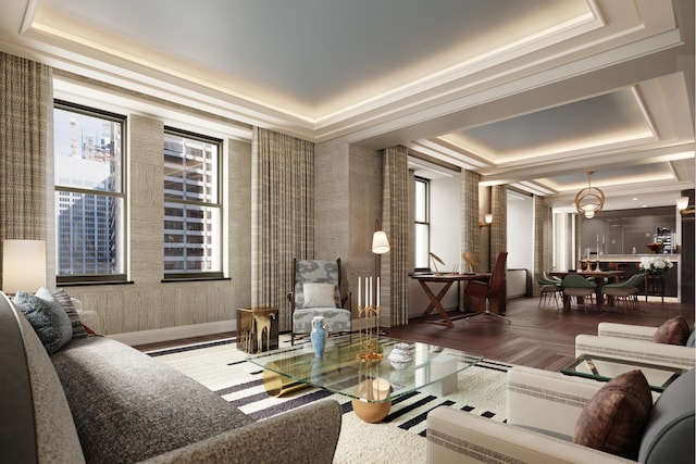 living area featuring a wealth of natural light, baseboards, and a raised ceiling