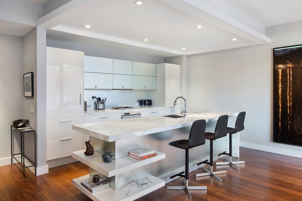 kitchen with a breakfast bar area, dark wood-type flooring, a sink, open shelves, and modern cabinets