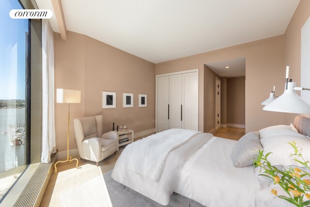 bedroom with wood finished floors, a closet, and baseboards