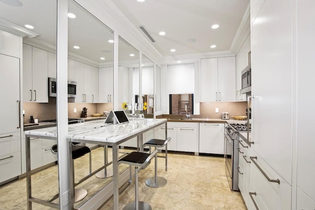 kitchen with crown molding, stainless steel appliances, and white cabinetry