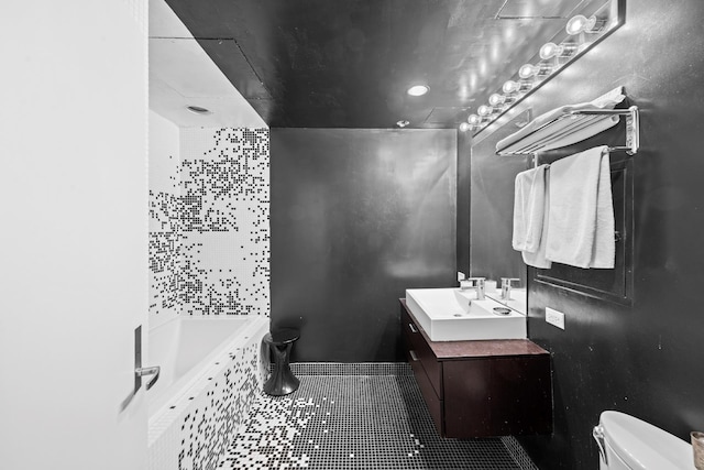 bathroom featuring toilet, tile patterned flooring, a relaxing tiled tub, and vanity