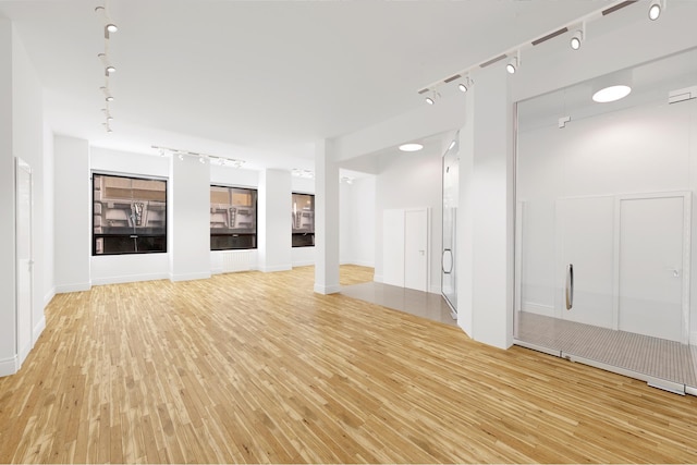 spare room featuring rail lighting and light wood-style flooring