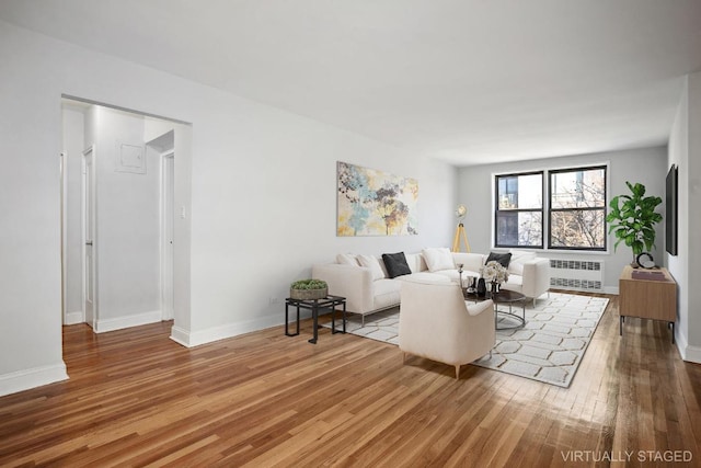 living area featuring baseboards, radiator heating unit, and wood finished floors