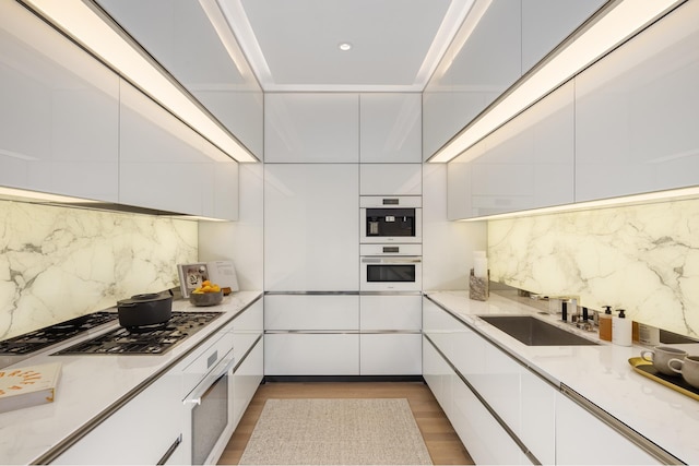 53 W 53rd St Unit 16F, New York City, NY 10019 - kitchen featuring modern cabinets, stainless steel gas cooktop, and white cabinetry