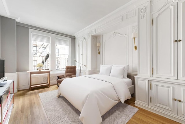 bedroom featuring crown molding and light hardwood / wood-style floors