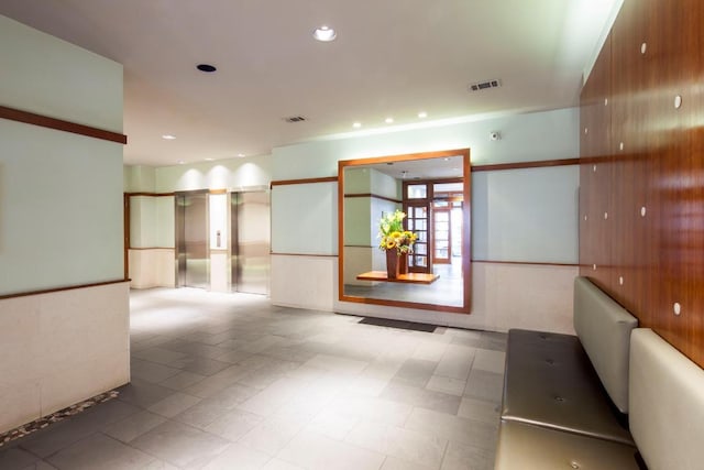 hallway with elevator and french doors