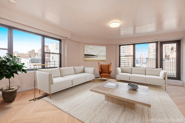 living area featuring a view of city, a wealth of natural light, and baseboards