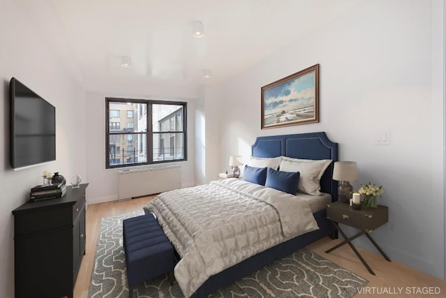 bedroom featuring radiator and light wood-type flooring