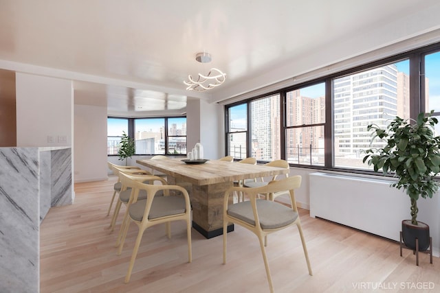 120 E 90th St Unit 15Ade, New York City, NY 10128 - dining space with light wood finished floors, plenty of natural light, a chandelier, and a view of city