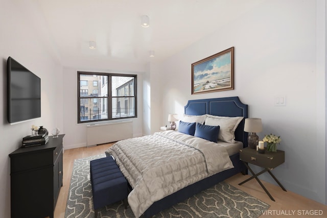 120 E 90th St Unit 15Ade, New York City, NY 10128 - bedroom featuring radiator heating unit, light wood-style floors, and baseboards
