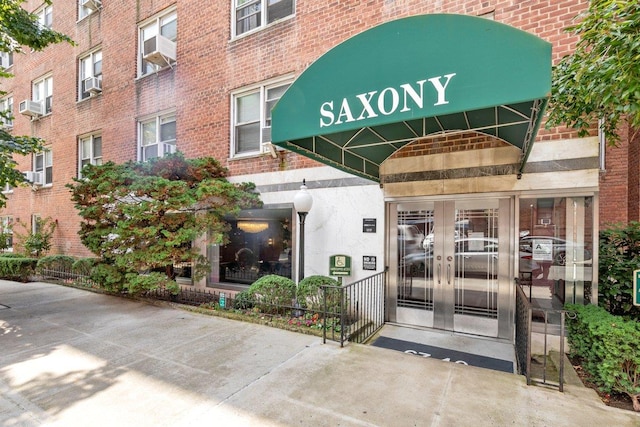 entrance to property featuring cooling unit and brick siding