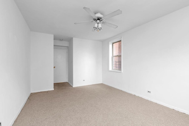 spare room featuring a closet, ceiling fan, and light colored carpet