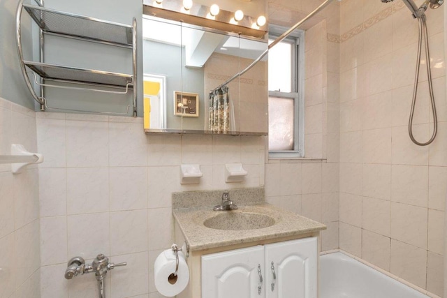 bathroom featuring tile walls, shower / bath combination with curtain, vanity, and tasteful backsplash