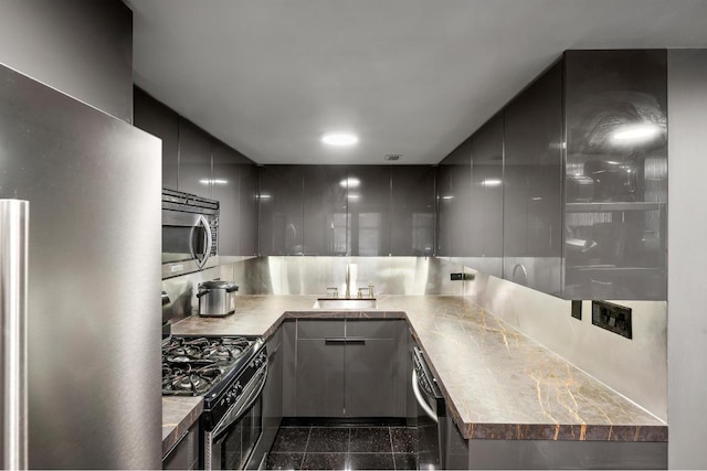 kitchen with appliances with stainless steel finishes, sink, and gray cabinetry