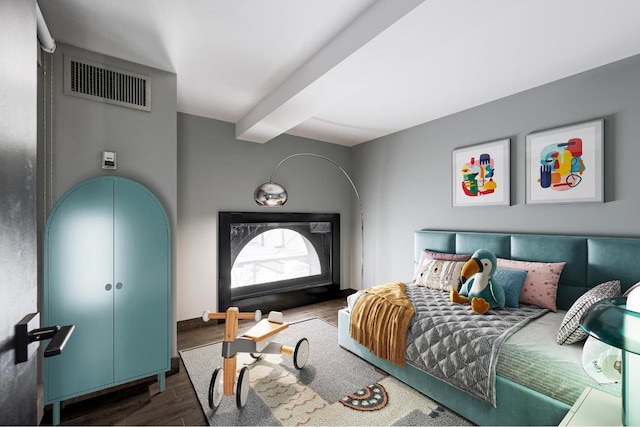 bedroom with dark wood-type flooring and beamed ceiling