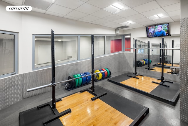 exercise room with a paneled ceiling and visible vents