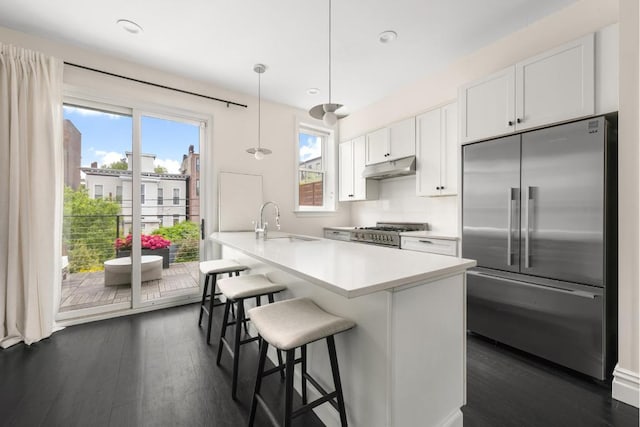 kitchen featuring white cabinetry, range, pendant lighting, stainless steel built in refrigerator, and sink