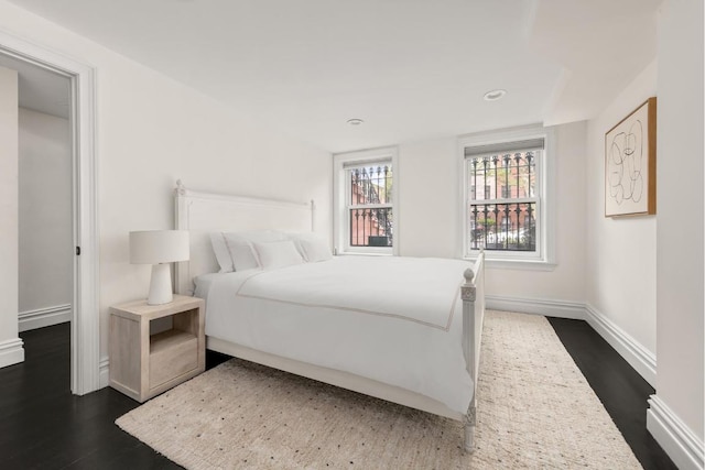 bedroom with dark hardwood / wood-style flooring