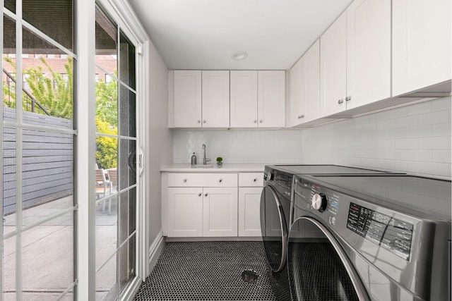 laundry room with cabinets, washer and dryer, and sink