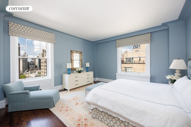 bedroom with dark hardwood / wood-style floors and multiple windows