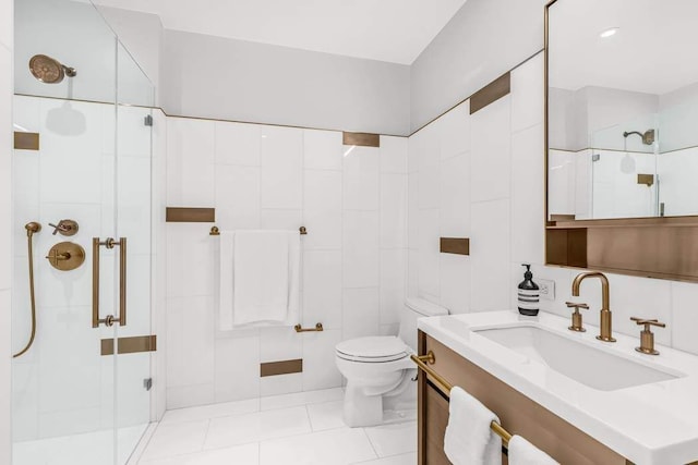 bathroom featuring tile walls, vanity, a tile shower, tile patterned floors, and toilet